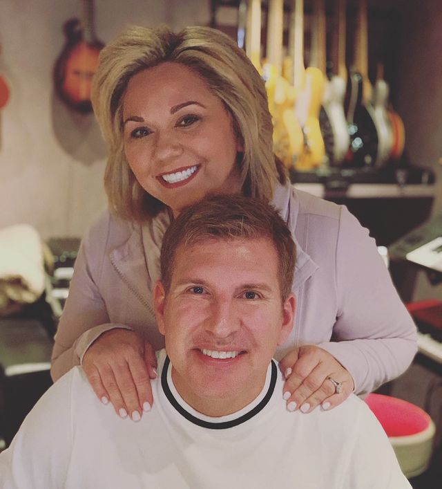 Chrisley is wearing white tee and his wife Julie is wearing cream color coat.